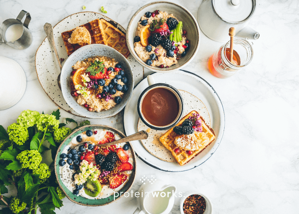 Breakfast spread with waffles, porridge and fruits